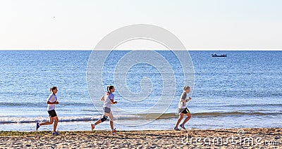 Three girls run on the beach Editorial Stock Photo