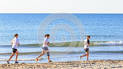 Three girls run on the beach Editorial Stock Photo