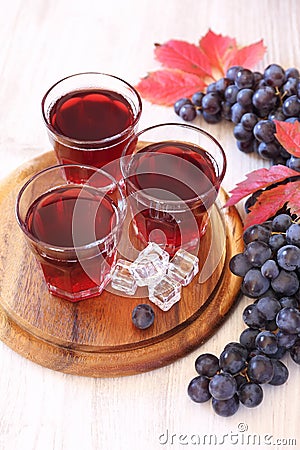 Three glasses of grape juice with ice and black grapes Stock Photo