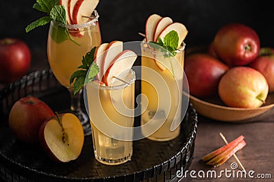 Three glasses of refreshing apple cocktail drinks with fresh red apples, dark background Stock Photo