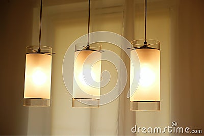 Three glowing lights lit over table Stock Photo