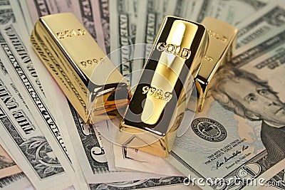 Three gold bars on dollar bills Stock Photo