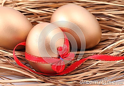 Three golden eggs in the nest Stock Photo