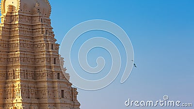 Three green Indian parrots flies away from temple of Virupaksha Stock Photo