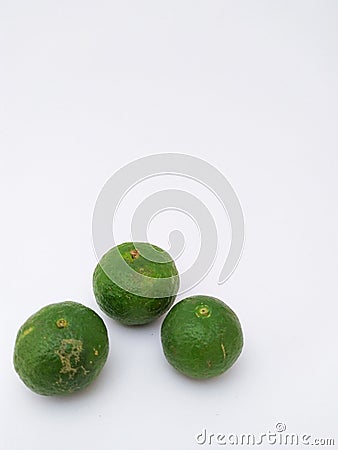 three green kaffir limes in portrait mode on a white background Stock Photo