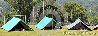 Three green tents mounted by scouts in a meadow Stock Photo
