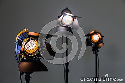 Three halogen spotlights with Fresnel lenses on a grey background. Photographing and filming in the interior Stock Photo