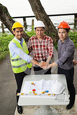 Three Hand of engineers take coordination and look to camera for make an agreement in investment about construction Stock Photo