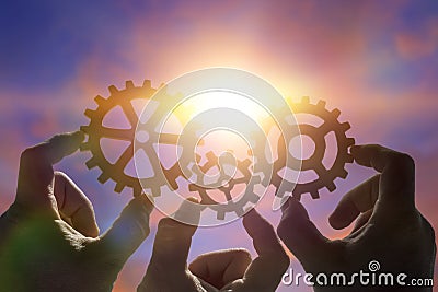 Three hands of businessmen collect the gear from the gears of the details of the puzzles. Stock Photo