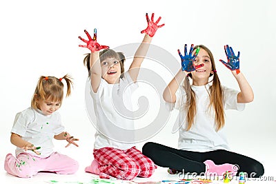 Three happy girls playing with finger colours Stock Photo