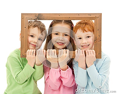 Three happy smiling kids looking picture frame Stock Photo