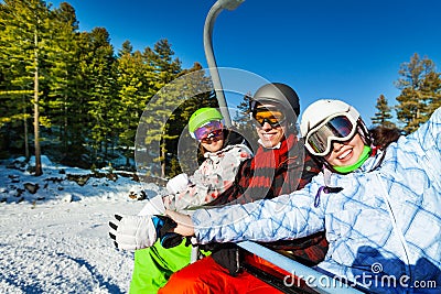 Three happy snowboarders sitting in elevator Stock Photo