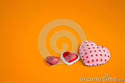 Three hearts on a bright orange texture background Stock Photo