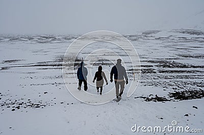 Three hikers on snow-covered trail to Askja Crater in northern Iceland. Stock Photo