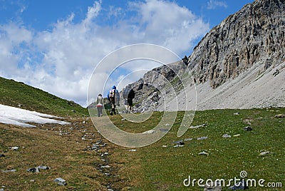 Three hikers walking along a mountain trail in Piedmont, Italy Editorial Stock Photo