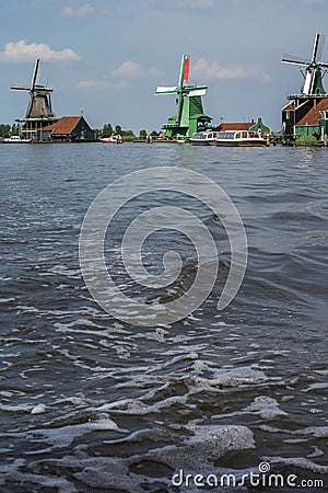 Three historical mills on the blue water in the day Stock Photo