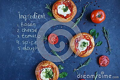 Three Homemade Mini Pizza with Tomatoes, Cheese and Bacon, Injuries and Spices on a dark background with a written recipe Stock Photo