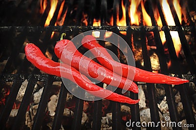 Three Hot Chili Peppers On The Flaming BBQ Grill Stock Photo