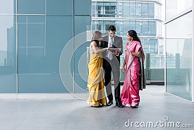 Three Indian business people using a tablet PC indoors Stock Photo