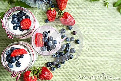 Three jars of yogurt with blueberries and strawberries, square. Stock Photo