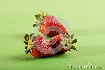 Three juicy strawberry on green background Stock Photo