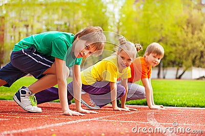 Three kids close-up in uniforms ready to run Stock Photo