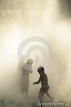 Three kids playing in a fountain Editorial Stock Photo