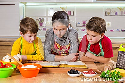 Three kids reading the cook book Stock Photo