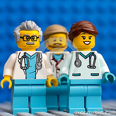Three Lego doctor minifigures standing against a blue baseplate background Editorial Stock Photo