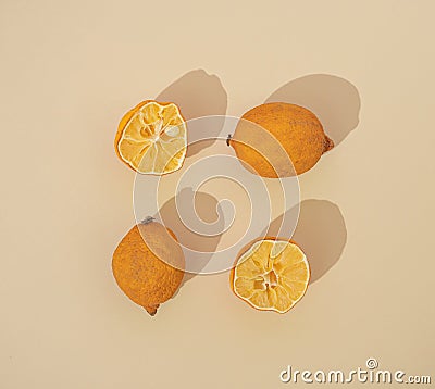 Three lemons partially dried on a pastel beige background arranged in a square shape. Flat lay design. Colorful citrus fruit. Stock Photo