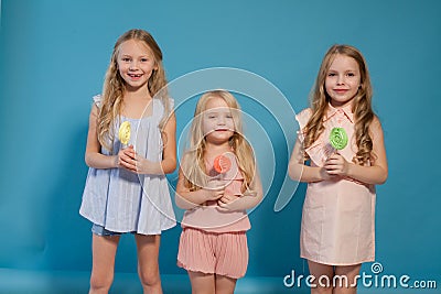 Three little girls girlfriend eaten sweet candy lollipop on a stick Stock Photo