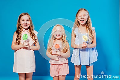 Three little girls girlfriend eaten sweet candy lollipop on a stick Stock Photo