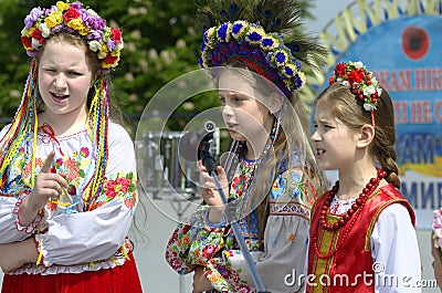 Three little girls in Ukrainian traditional embroidery costumes singing during concert devoted to the Remembrance Day Editorial Stock Photo