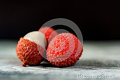 Three lychee fruits on dark background close Stock Photo