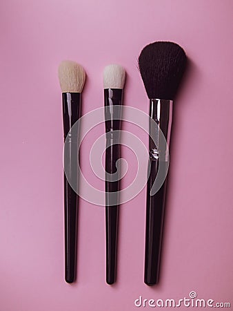 three makeup brushes on a pink background. professional brushes for mascara and powder. Stock Photo