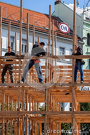Three male carpenters building a wooden frame structure in Prague. Editorial Stock Photo