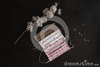 Three masks, white with small stars and beige polka dots and pink on a black background. Stock Photo