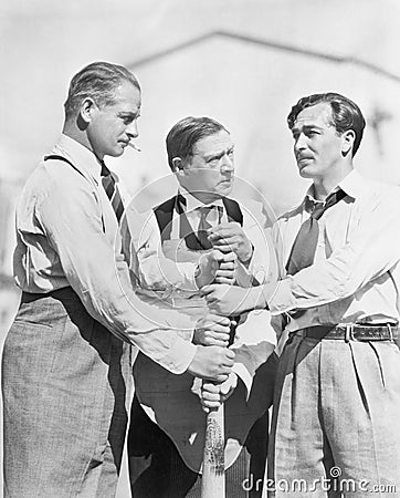 Three men competing who will start first on a baseball bat Stock Photo