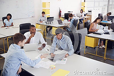 Three men working together in a busy office, elevated view Stock Photo