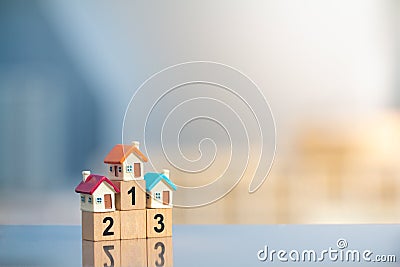 Three miniature houses on first place of winner podium on modern city background Stock Photo