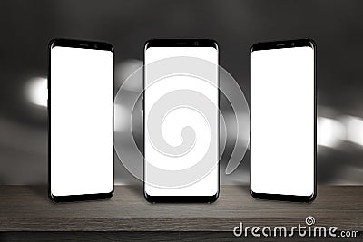 Three mobile phones with screen for mockup on the table Stock Photo