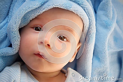 Three month old baby wrapped in blue blanket Stock Photo