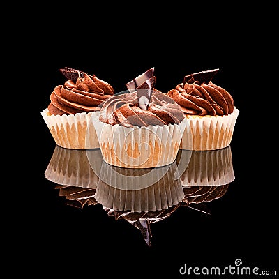 Three muffin cupcake with brown cream and pieces of chocolate Stock Photo