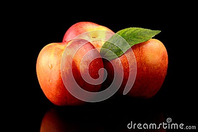 Three nectarines with leaf isolated on black Stock Photo