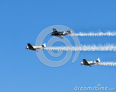 Three North American Aviation T-6 flying over Duck Creek with other Warbirds prior to the traditional fireworks display. Editorial Stock Photo