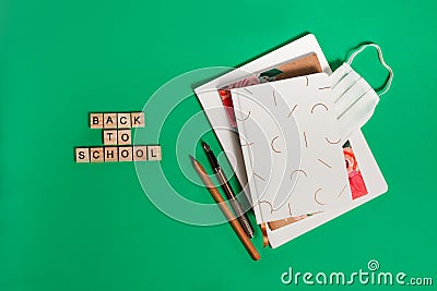 Three notebooks on green background with ink pen and copy spaces. Journal writing and note taking concept Stock Photo