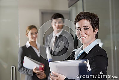 Three office workers at door of boardroom Stock Photo
