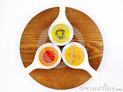 Three oils with spices in bowls Stock Photo