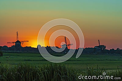 Three old windmills from the year 1672 in Stompwijk Molendriegang Stompwijk, the Netherlands during a beautiful sunset Stock Photo