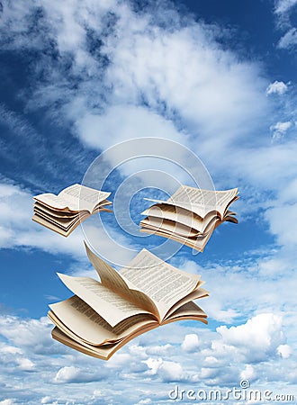 Three open books flying on blue sky Stock Photo